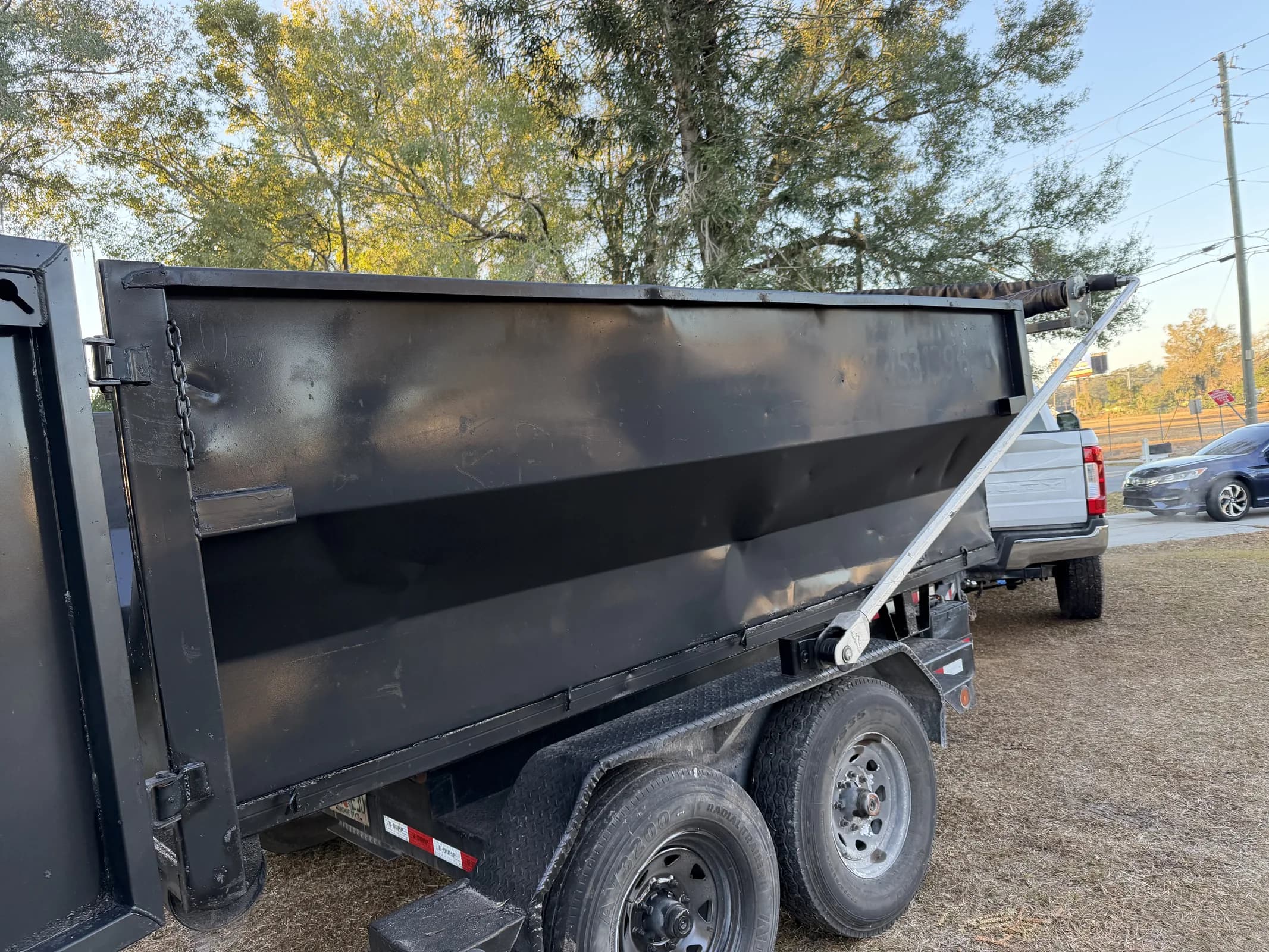 Low-profile black 12-yard dumpster on a trailer